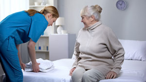 senior smiling at nurse who is telling her about their community amentities