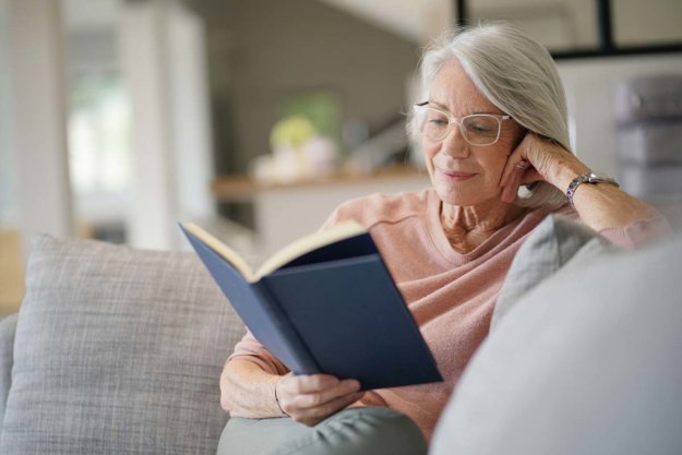 woman reading a book and enjoying independent living